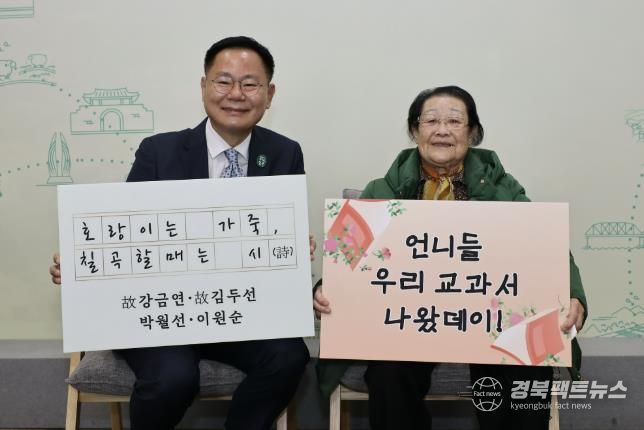 김재욱 칠곡군수와 천재교과서에 자신의 시가 실린 이원순 할머니가 교과서 수록을 기념하는 푯말을 들고 있다.