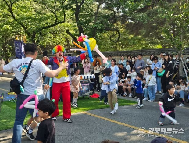 대릉원 돌담길 상생마켓서 펼쳐진 거리 공연... 경주 대릉원 돌담길 일원에서 열린 '2025 경주 대릉원 돌담길 상생마켓' 행사에서 광대 복장의 공연자가 어린이들과 함께 풍선 놀이를 하며 관객들의 큰 호응을 얻고 있다.
