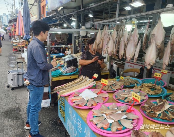 죽도시장에서 수산물과 수산가공식품의 시료를 체취하고 있다.